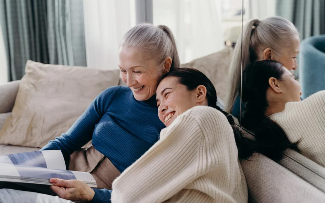 Grandmother and daughter sitting down reading together